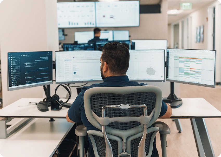 An IT professional monitors multiple systems in a secure operations center, showcasing BCA’s real-time threat detection and advanced cybersecurity services.