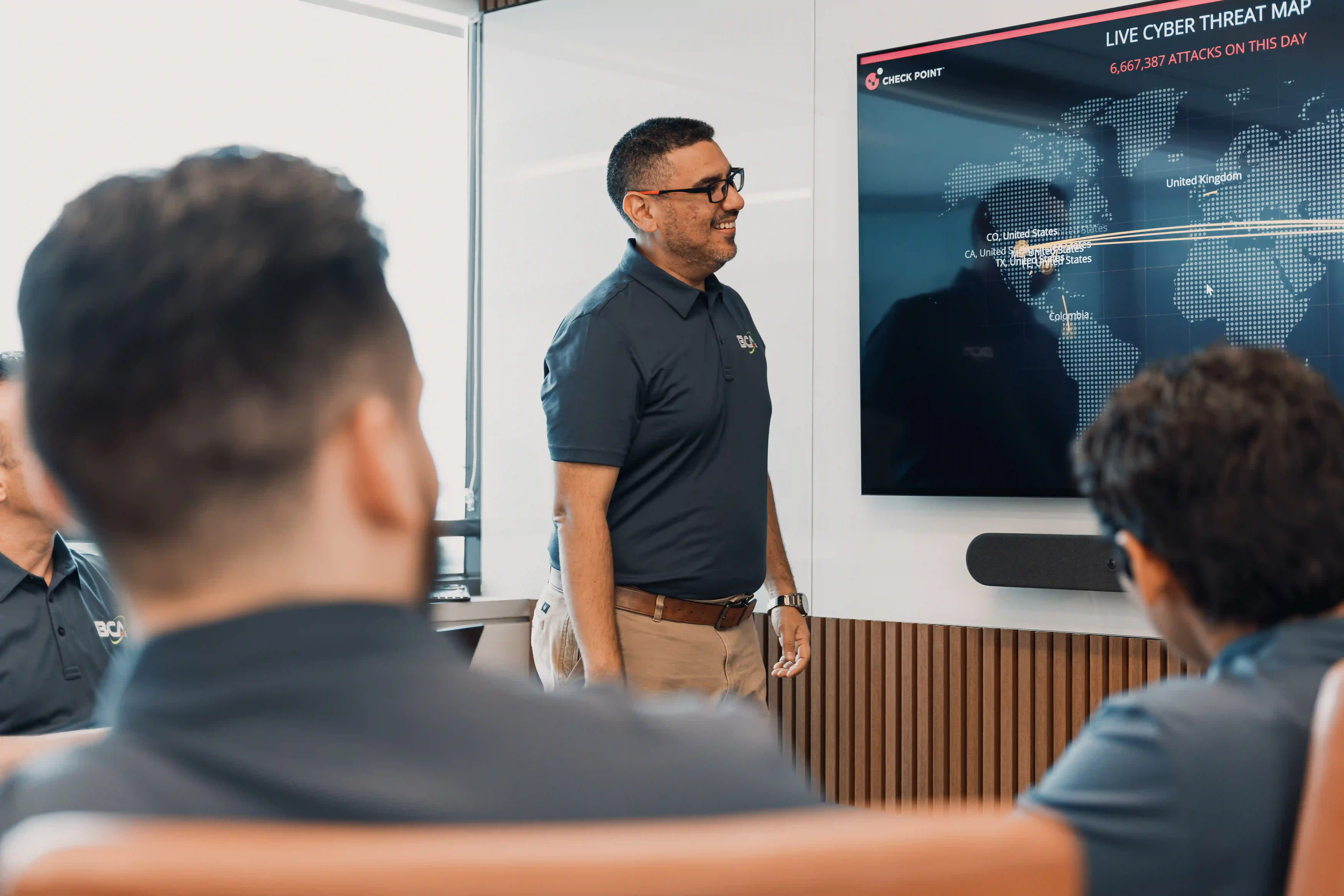 A BCA team member presents a live cyber threat map during a strategy session, showcasing how co-managed IT services enhance visibility and strengthen cybersecurity defenses.