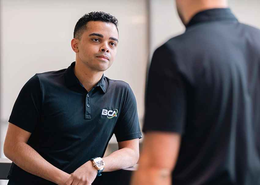 BCA IT professional greeting a client with a handshake.