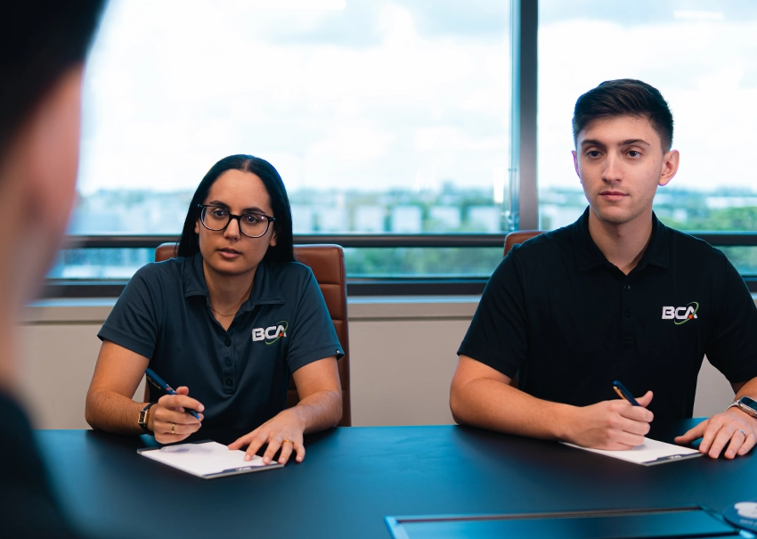 Two BCA IT professionals listening during a technology consultation.