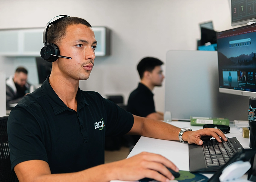 BCA IT specialist monitoring client systems from multiple screens.