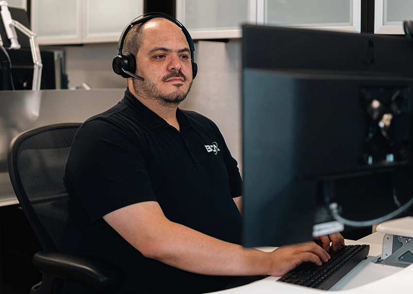 BCA IT support technician assisting clients from a workstation.