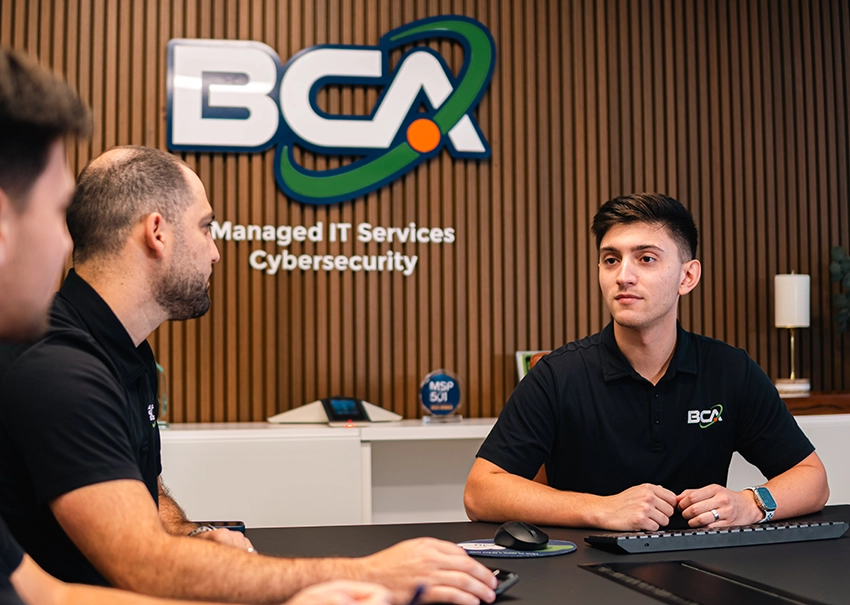 BCA IT team members collaborating during an office meeting.