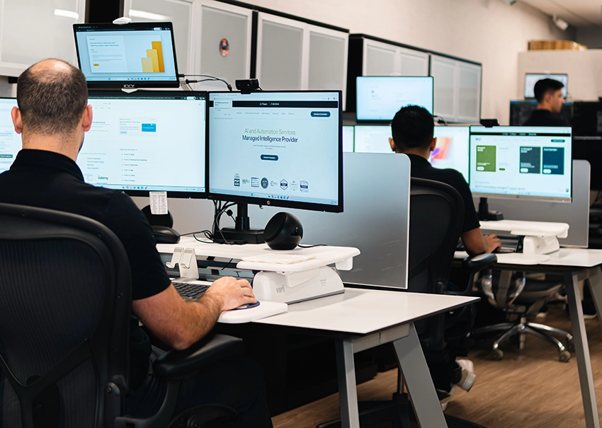 BCA IT operations team monitoring systems across multiple workstations.