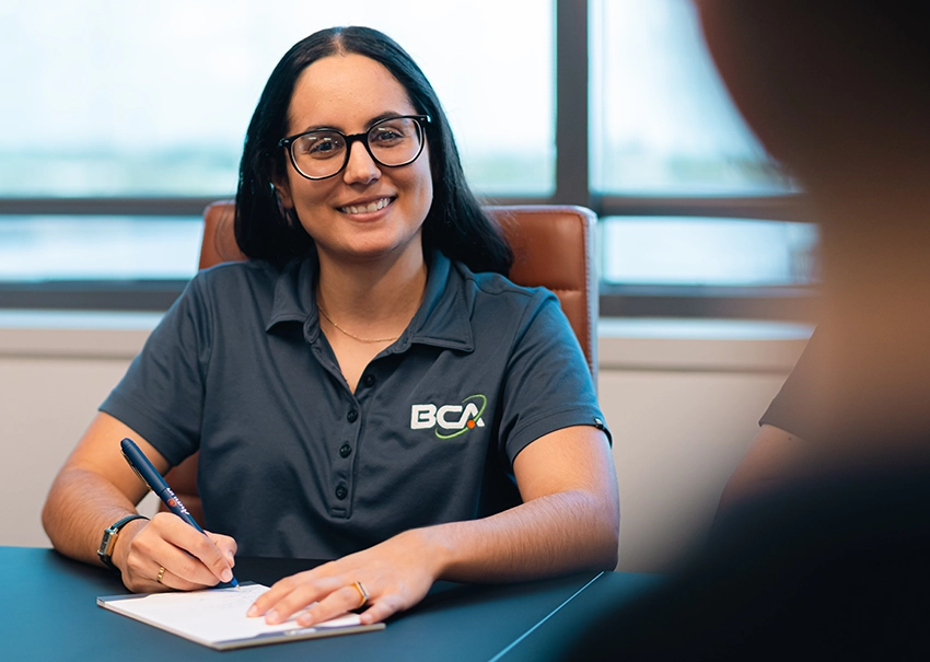 BCA IT consultant taking notes during a meeting.
