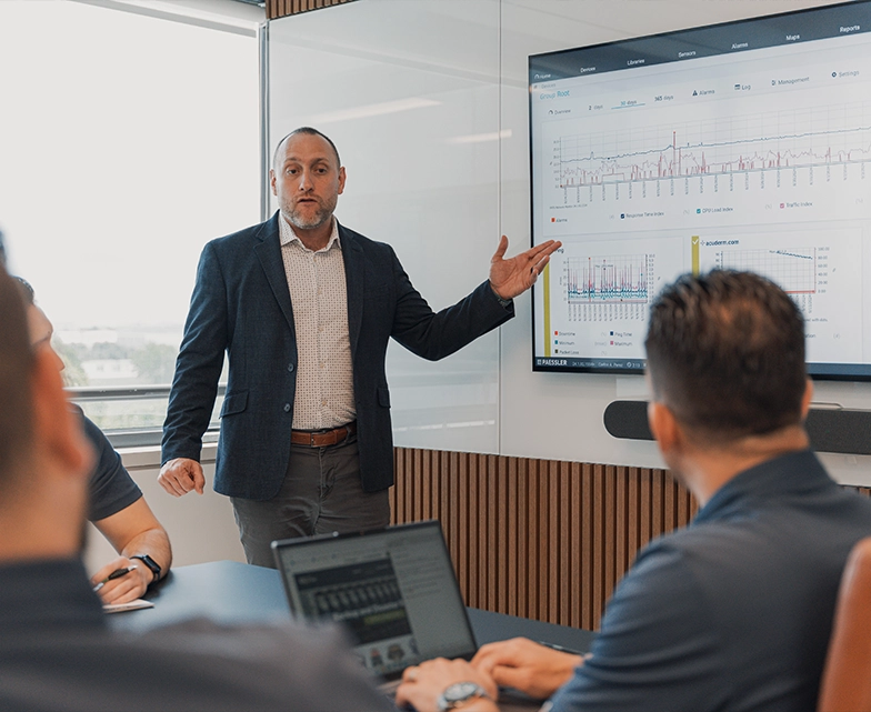 BCA team leader presenting performance dashboards on a screen during a meeting.